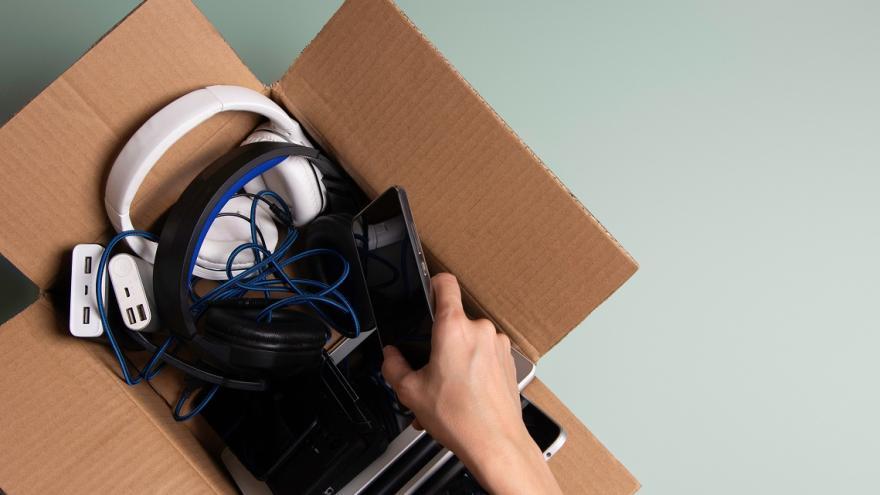 Jemand sucht nach Elektrogeräten in einer Kiste